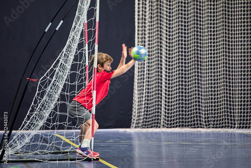 Fotografie Détermination juvénile, enfant de huit ans gardien débutant arrêtant le ballon a