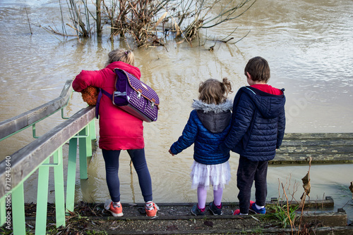 Émerveillement aquatique, trois enfants admirant la rivière débordée