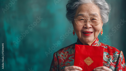 portrait of a senior woman holding red envelope hong bao with happy face