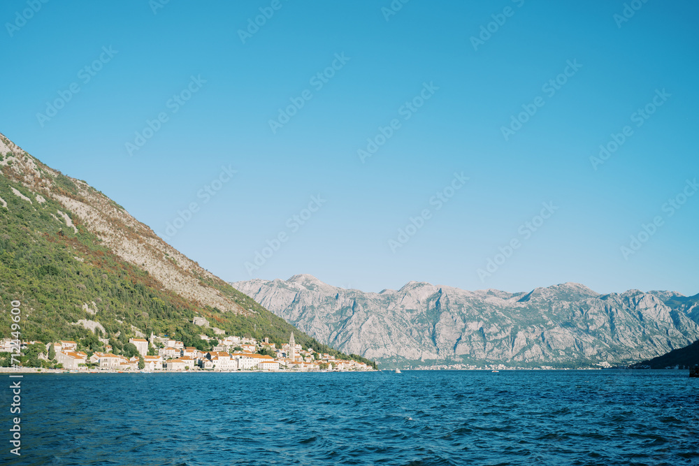 View from the sea of the coast of Perast at the foot of the mountains surrounded by a mountain range. Montenegro