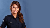 Brunette woman in police uniform smiling isolated on pastel background