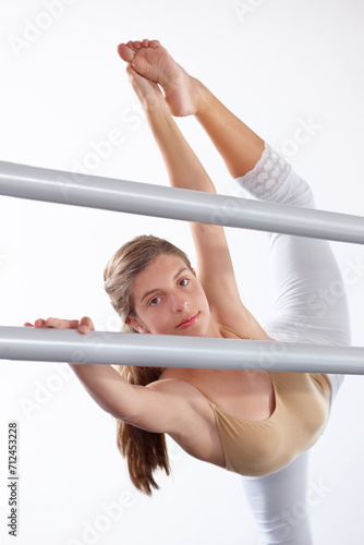 Portrait, ballet and girl stretching legs on barre in classroom, practice and student exercise. Ballerina, flexibility and warm up for training, dance choreography for art or performance for fitness photo
