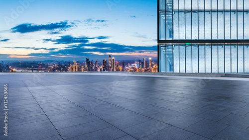 Empty square floor and glass wall with city skyline at night in Chongqing