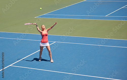 Woman, serving and game of tennis on court for sport, competition and start playing with ball and racket. Athlete, training and exercise outdoor with challenge on turf in summer match and contest