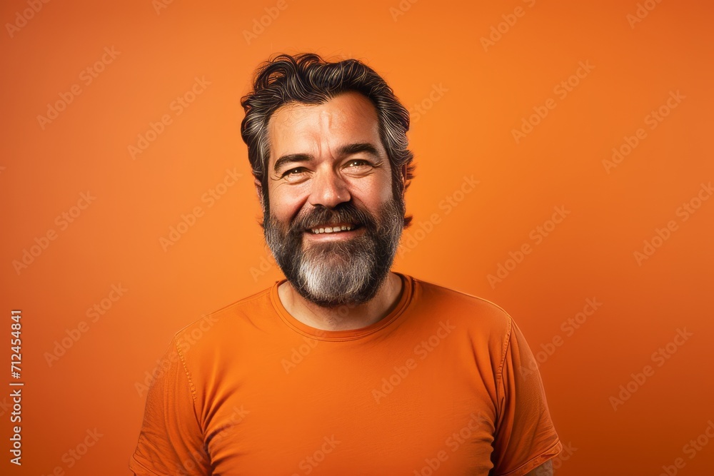 Handsome bearded man with orange t-shirt on orange background Handsome bearded man with orange t-shirt on orange background
