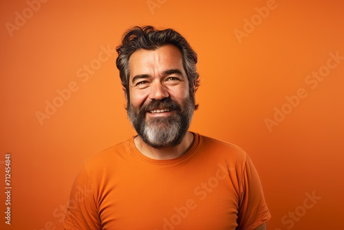 Handsome bearded man with orange t-shirt on orange background