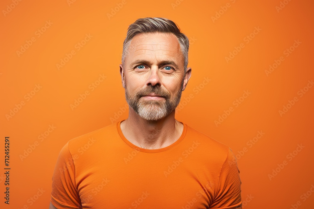 Portrait of mature man in orange t-shirt on orange background Portrait of mature man in orange t-shirt on orange background