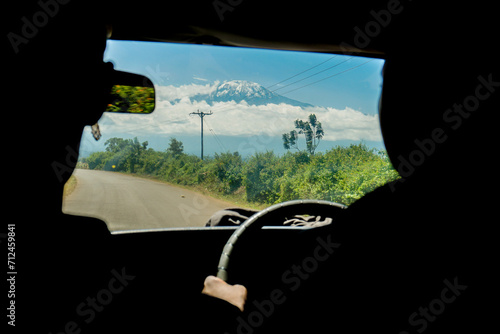 Driving to the Kilimajaro Machame route start in Tanzania - adventure travel to the summit of the highest mountain of the Africa - window view photo