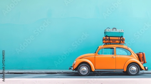 Classic orange car with suitcases on top ready fort vacations. Light blue background. Holidays and travel concept. © suphakphen