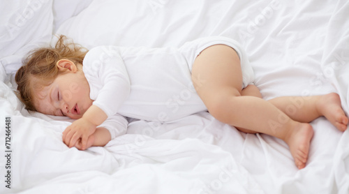 Baby, kid and sleeping on bed for calm break, peace and dream to relax at home from above. Tired, cozy or young child asleep for newborn development, healthy childhood growth and rest in nursery room