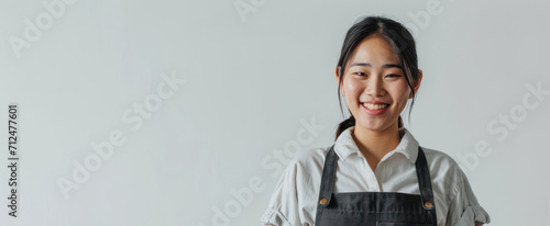 young smiling welcome asian female woman business owner wear apron hand holding tablet ready for your order on white color background, restaurant, pretty, uniform photo