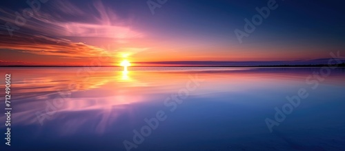 Sunrise or sunset reflecting on still water fading into the distance.