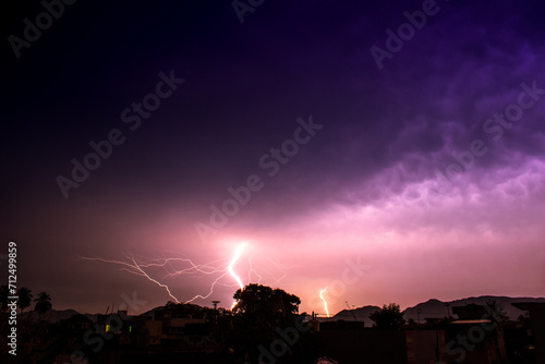 Behold the mesmerizing beauty of a purple sky, illuminated by a distant lightning bolt. Nature's artwork never fails to amaze