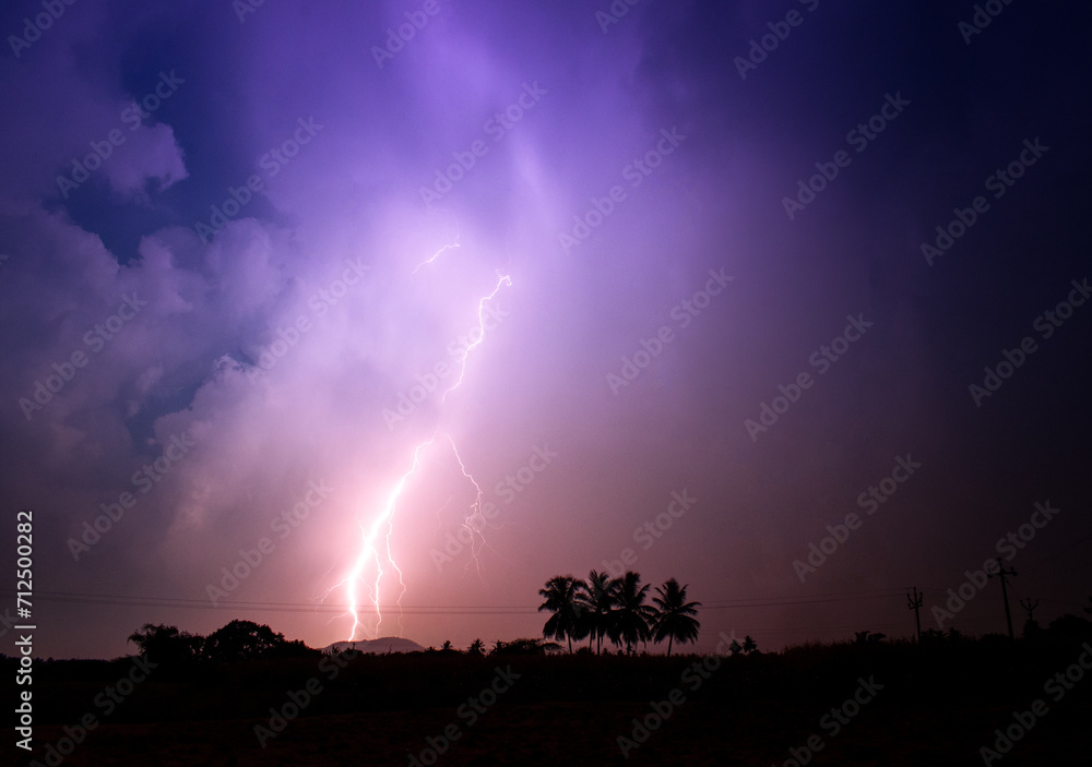 Brace yourself for an electrifying spectacle as a magnificent lightning storm dances above a picturesque line of palm trees. Witness the raw beauty of nature's fury Brace yourself for an electrifying spectacle as a magnificent lightning storm dances above a picturesque line of palm trees. Witness the raw beauty of nature's fury