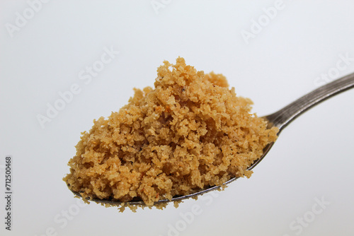 Crumbs which often served along with traditional Javanese fried chicken or fried duck, called kremesan. One spoon. Isolated on white background photo