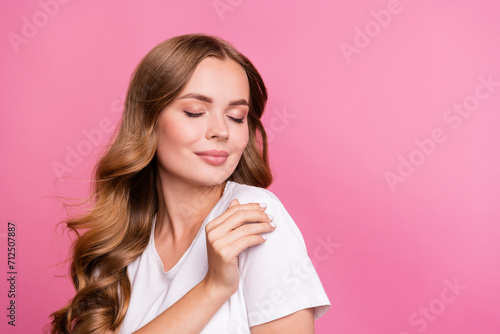 Portrait of tender girl with fluttering curly hair dressed white t-shirt close eyes smell fresh clothes isolated on pink color background