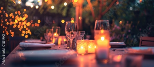 Outdoor dinner with candlelit glasses.