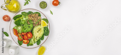 healthy vegan lunch bowl with broccoli, avocado, quinoa and tomatoes on a white background. Long banner format. top view