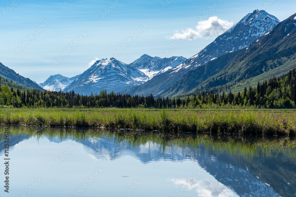 Tern Lake along Seward Highway on Kenai Peninsula in Alaska. At junction with Sterling Highway in Chugach National Forest. Mountain landscape perfectly reflected in mirror still alpine lake.