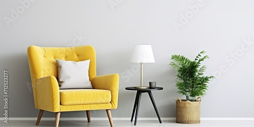 Stylish and luxurious interior with honey yellow armchair, gray frame, gold lamp, mirror, plant, pillow, and elegant accessories. Modern living room decor. Actual image. Template. © Sona