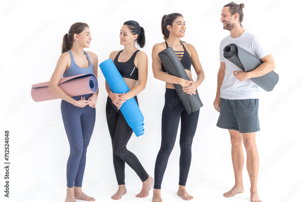 Obraz premium Group of happy sporty women and guy wearing body stylish sportswear holding personal carpets leaned on a white background. waiting for yoga class or body weight class. healthy lifestyle and wellness