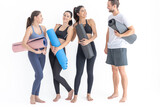 Group of happy sporty women and guy wearing body stylish sportswear holding personal carpets leaned on a white background. waiting for yoga class or body weight class. healthy lifestyle and wellness