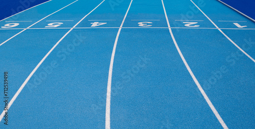 Olympic track lanes with white stripes and start and finish numbers  empty Blue background for copy space  concept of physical sports and running  symbolizing commitment and paths to goals