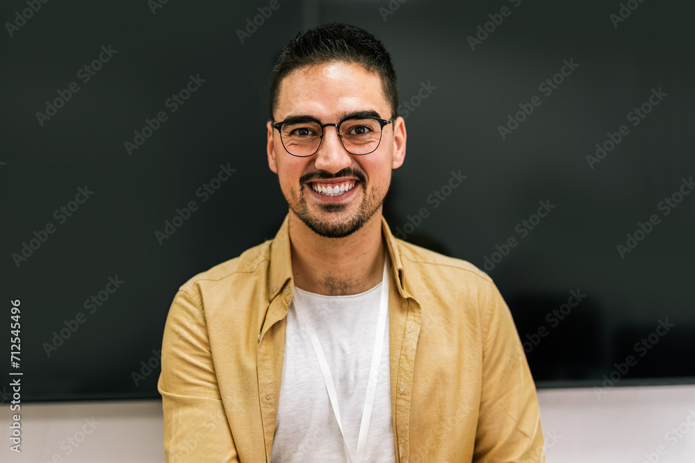 Obraz premium Portrait of a smiling male coach presenting to an audience in the lecture hall.