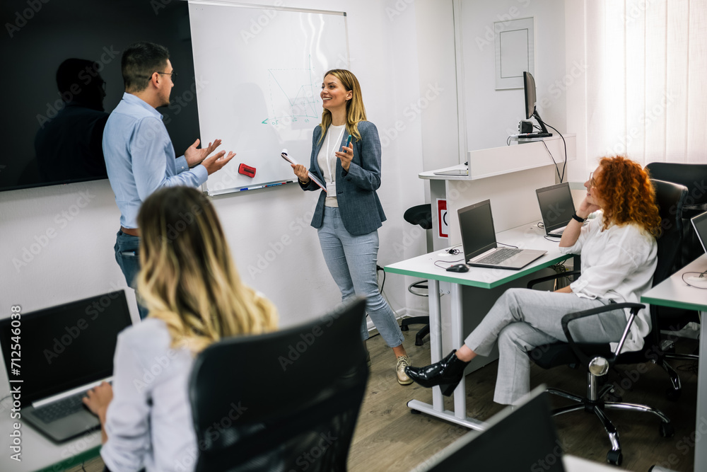 Obraz premium Young teachers teaching young students a programming class in the classroom.