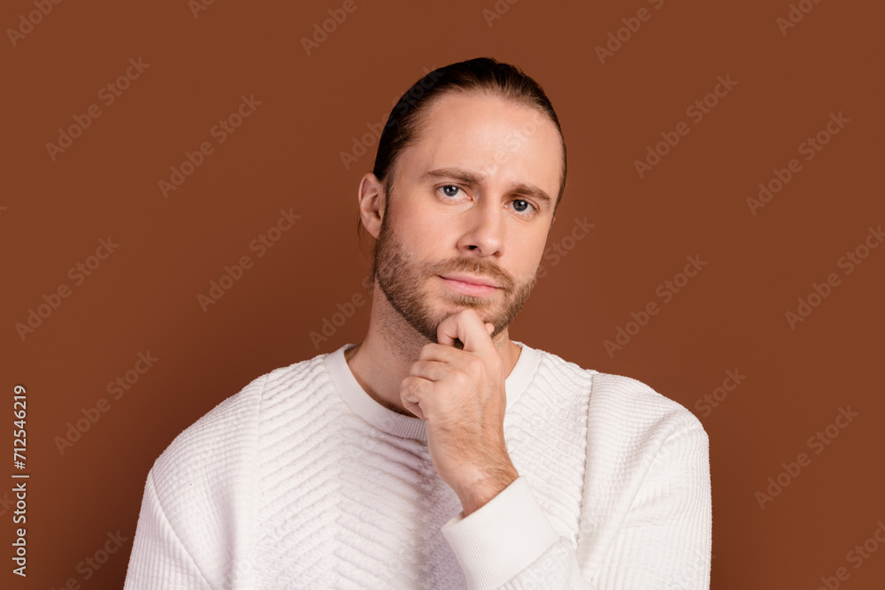 Photo of uncertain serious guy dressed white pullover arm chin thinking isolated brown color background