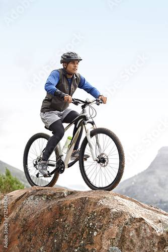 Sports, athlete and a man on a bike on the mountain for cycling, training and travel in nature. Idea, health and a male cyclist on a hill with a bicycle for riding, exercise and an outdoor workout © Alexandra/peopleimages.com