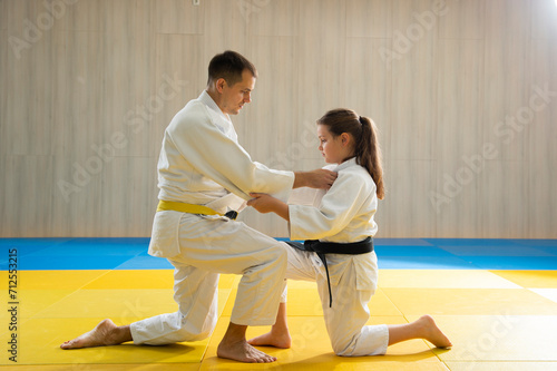 Young yellow belt judo man and young black belt judo girl