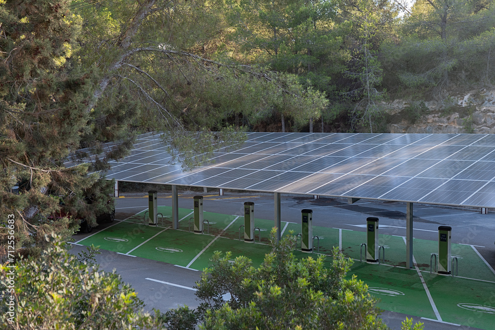 © ADDICTIVE STOCK - A spacious parking lot equipped with multiple solar panel canopies providing power to a row of electric vehicle charging stations © ADDICTIVE STOCK - A spacious parking lot equipped with multiple solar panel canopies providing power to a row of electric vehicle charging stations