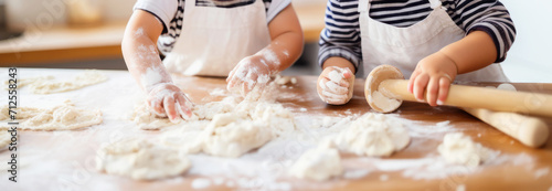 children's hands rolled dough with a rolling pin on the black table