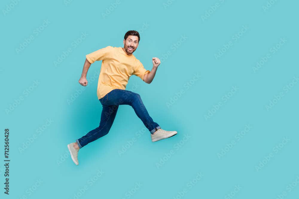 Full body size photo of funky positive man in air jumping ambitious running sportsman practicing isolated on aquamarine color background