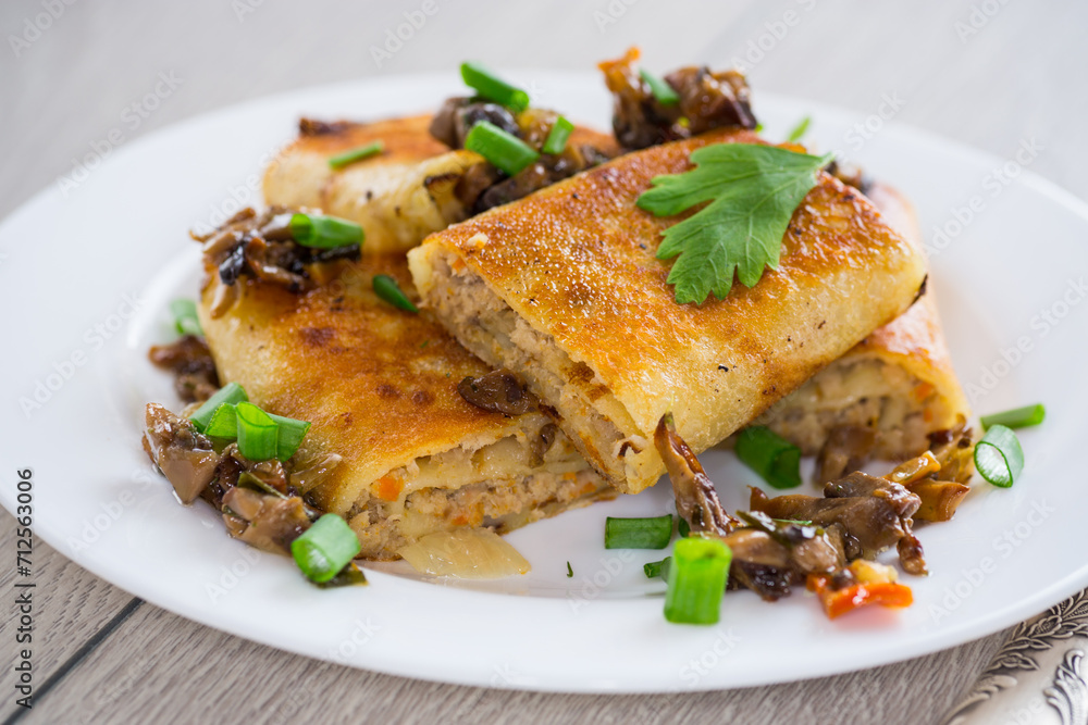 fried thin pancakes stuffed with meat and mushrooms. fried thin pancakes stuffed with meat and mushrooms.