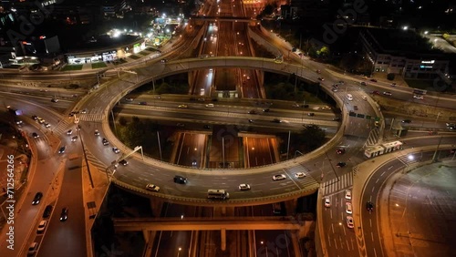 Aerial drone night cinematic video of illuminated urban elevated toll ring road junction and interchange overpass passing through Kifisias Avenue, Attica, Greece photo