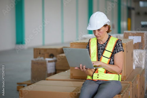 senior worker working on laptop computer in the warehouse storage