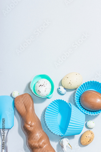 Easter baking concept background. Sweet eggs, chocolate rabbit, kitchen utensil. Cooking tools