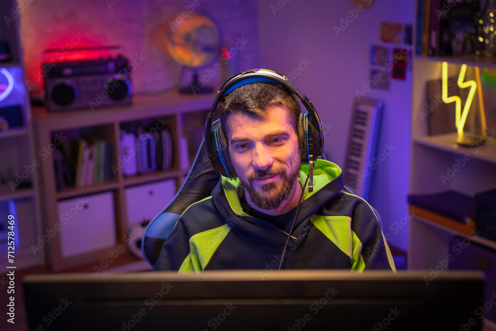 Happy gamer portrait playing games on the computer streaming gaming room. High quality photo Happy gamer portrait playing games on the computer streaming gaming room. High quality photo