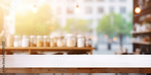 Cafe background with white table surface for displaying food and products, wood shelf for shop presentation, empty white wood table top, counter with blurred bokeh light, retail store banner.