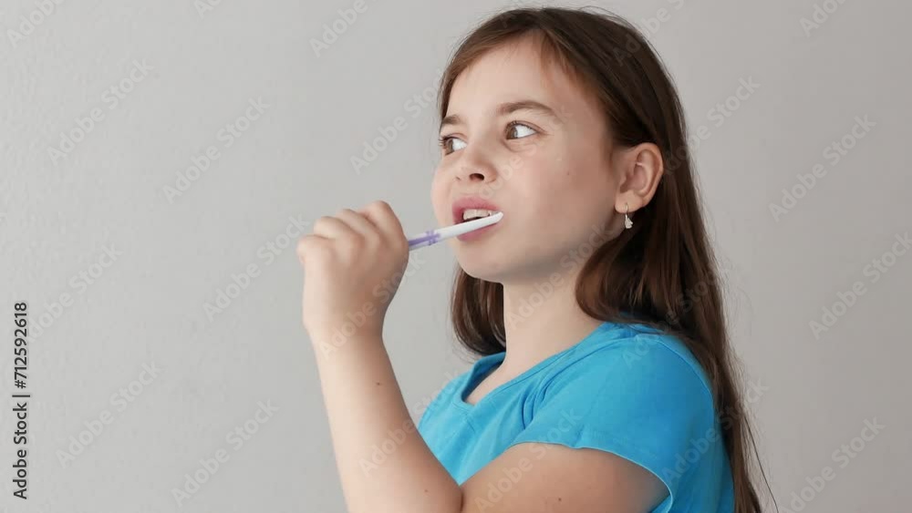 A thoughtful little girl brushes her teeth with toothpaste at home, oral hygiene. The concept of the morning. A thoughtful little girl brushes her teeth with toothpaste at home, oral hygiene. The concept of the morning.
