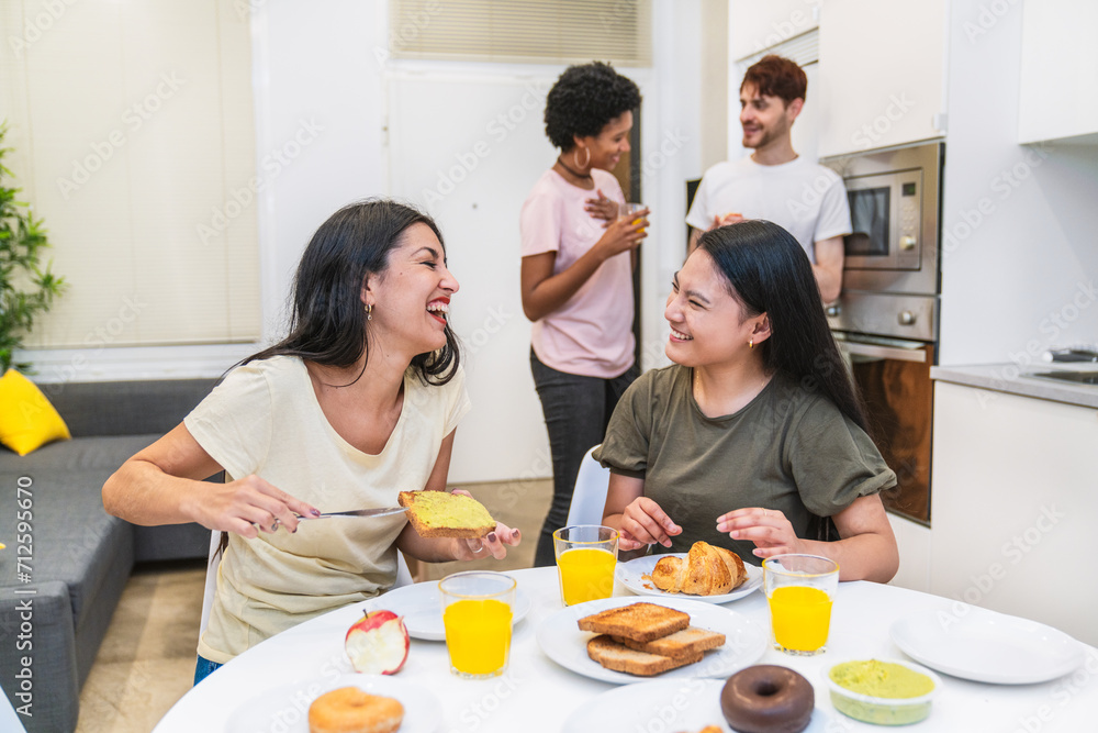 Laughter fills the room as friends engage in joyful conversation around a breakfast table with various foods. Laughter fills the room as friends engage in joyful conversation around a breakfast table with various foods.