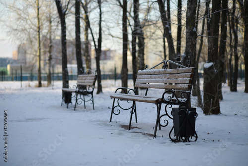 park bench on a winter alley at snowfall. bench with snow after snowstorm or in snow calamity in europe © alexkich
