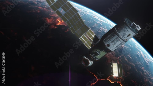 A broken satellite, surrounded by spare parts, flies in space against a planet engulfed in fire