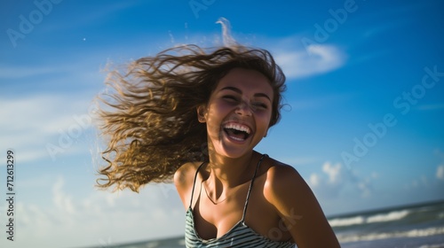 A teenage girl happily enjoying herself on a sunny beach during a warm day. girl on the beach in the summer. travelling alone concept, happy moment. 