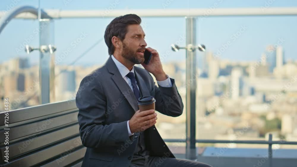 Relaxed entrepreneur talking mobile phone on terrace. Happy bearded man speaking Relaxed entrepreneur talking mobile phone on terrace. Happy bearded man speaking