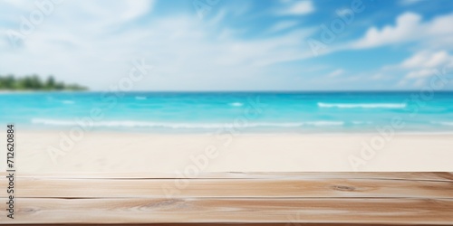 Blurred blue sea and white sand beach backdrop with a wooden tabletop.