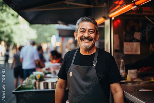 Smiling portrait of a middle aged mexican man working in food truck photo
