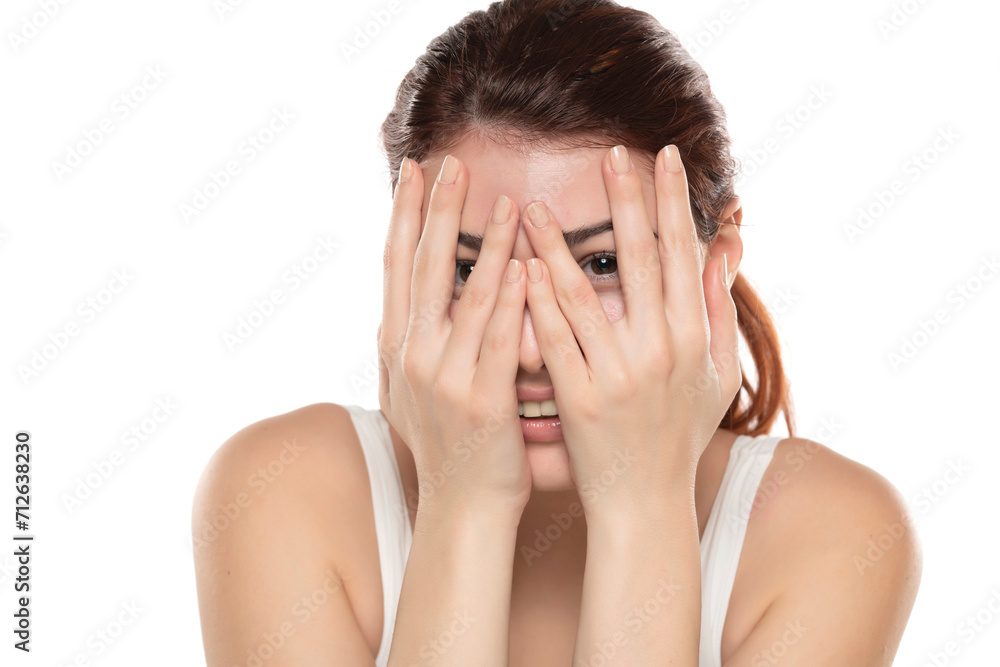 Portrait of yong happy ashamed woman, covering face with hands, beautiful model posing in white studio background. Portrait of yong happy ashamed woman, covering face with hands, beautiful model posing in white studio background.